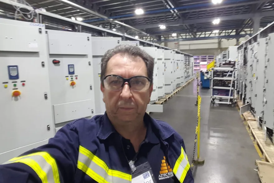 Profissional identificado com a Aztec Energia em ambiente industrial de fabricação de painéis